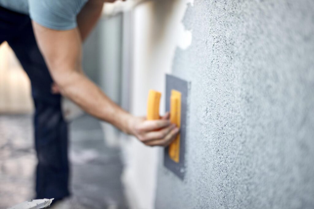 man working on a house facade, residential repairs management